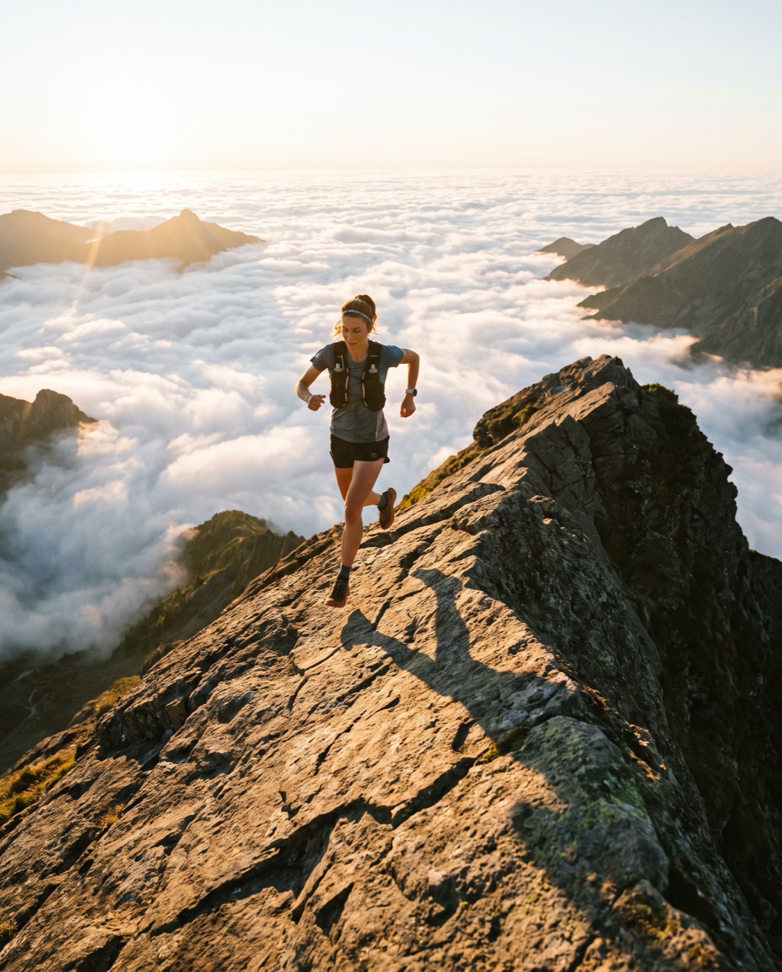 Trail runner on a mountain ridgeline at sunrise